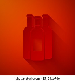 Paper cut Bottles of wine icon isolated on red background. Paper art style. Vector Illustration