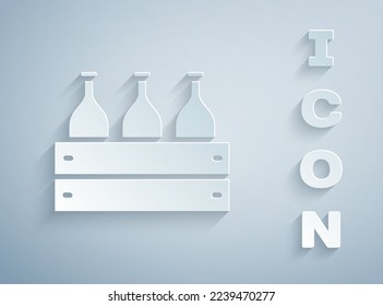 Paper cut Bottles of wine in a wooden box icon isolated on grey background. Wine bottles in a wooden crate icon. Paper art style. Vector Illustration