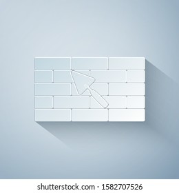 Paper cut Brick wall with trowel icon isolated on grey background. Paper art style. Vector Illustration