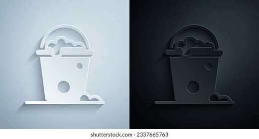 Paper cut Bucket with foam and bubbles icon isolated on grey and black background. Cleaning service concept. Paper art style. Vector