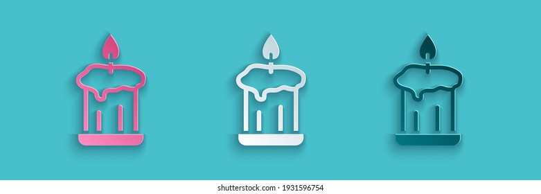 Paper cut Burning candle in candlestick icon isolated on blue background. Old fashioned lit candle. Cylindrical candle stick with burning flame. Paper art style. Vector