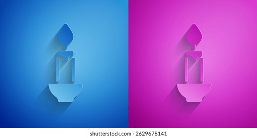 Paper cut Burning candle icon isolated on blue and purple background. Cylindrical candle stick with burning flame. Paper art style. Vector