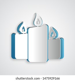 Paper cut Burning candles icon isolated on grey background. Old fashioned lit candles. Cylindrical aromatic candle sticks with burning flames. Paper art style. Vector Illustration