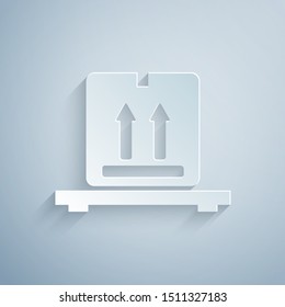 Paper cut Cardboard boxes on pallet icon isolated on grey background. Closed carton delivery packaging box with fragile signs. Paper art style. Vector Illustration