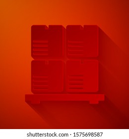 Paper cut Cardboard boxes on pallet icon isolated on red background. Closed carton delivery packaging box with fragile signs. Paper art style. Vector Illustration
