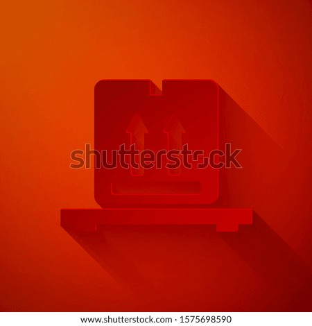 Paper cut Cardboard boxes on pallet icon isolated on red background. Closed carton delivery packaging box with fragile signs. Paper art style. Vector Illustration
