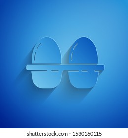 Paper cut Chicken egg in box icon isolated on blue background. Paper art style. Vector Illustration