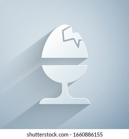 Paper cut Chicken egg on a stand icon isolated on grey background. Happy Easter. Paper art style. Vector Illustration