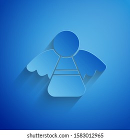 Paper cut Christmas angel icon isolated on blue background. Paper art style. Vector Illustration
