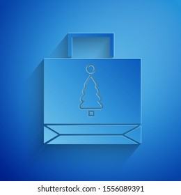 Paper cut Christmas paper shopping bag icon isolated on blue background. Package sign. Merry Christmas and Happy New Year. Paper art style. Vector Illustration