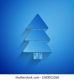 Paper cut Christmas tree icon isolated on blue background. Merry Christmas and Happy New Year. Paper art style. Vector Illustration