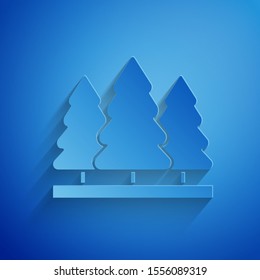 Paper cut Christmas trees icon isolated on blue background. Merry Christmas and Happy New Year. Paper art style. Vector Illustration