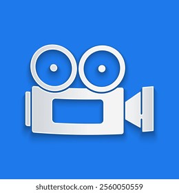 Paper cut Cinema camera icon isolated on blue background. Video camera. Movie sign. Film projector. Paper art style. Vector Illustration