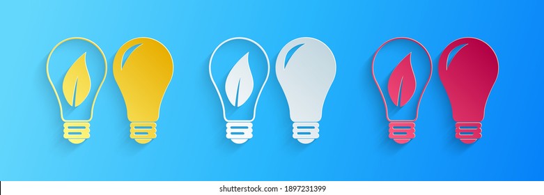 Paper cut Classic Lamp and Light bulb with leaf inside icon isolated on blue background. Lighting electric lamp. Green eco energy concept. Paper art style. Vector.