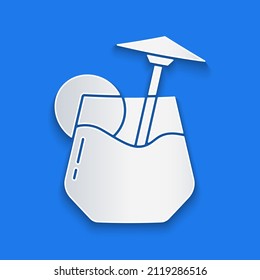 Paper cut Cocktail and alcohol drink with umbrella icon isolated on blue background. Paper art style. Vector