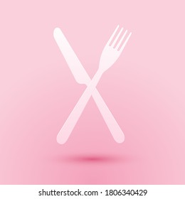 Paper cut Crossed fork and knife icon isolated on pink background. Restaurant icon. Paper art style. Vector.
