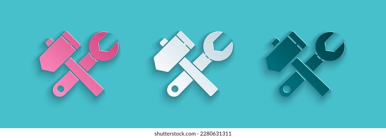 Paper cut Crossed hammer and wrench spanner icon isolated on blue background. Hardware tools. Paper art style. Vector Illustration