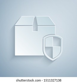 Paper cut Delivery pack security symbol with shield icon isolated on grey background. Delivery insurance. Insured cardboard boxes beyond the shield. Paper art style. Vector Illustration