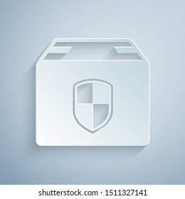 Paper cut Delivery pack security symbol with shield icon isolated on grey background. Delivery insurance. Insured cardboard boxes beyond the shield. Paper art style. Vector Illustration