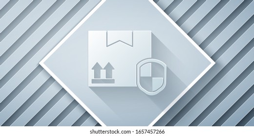 Corte de papel Seguridad del paquete de entrega con el icono de escudo aislado en fondo gris. Seguro de entrega. Caja de cartón asegurada más allá de la pantalla. Estilo de arte de papel.  Ilustración vectorial