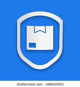 Paper cut Delivery pack security with shield icon isolated on blue background. Delivery insurance. Insured cardboard boxes beyond the shield. Paper art style. Vector Illustration