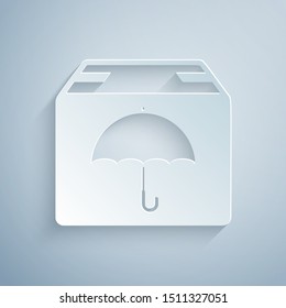 Paper cut Delivery package with umbrella symbol icon isolated on grey background. Parcel cardboard box with umbrella sign. Logistic and delivery. Paper art style. Vector Illustration