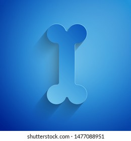 Paper cut Dog bone icon isolated on blue background. Pets food symbol. Paper art style. Vector Illustration