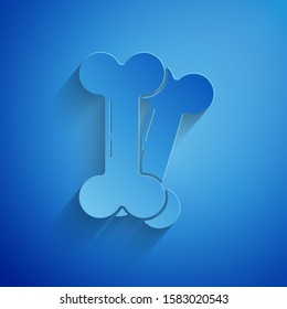 Paper cut Dog bone icon isolated on blue background. Pets food symbol. Paper art style. Vector Illustration