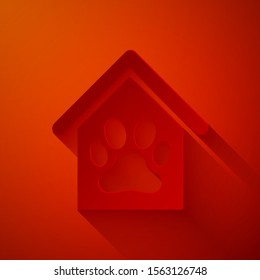 Paper cut Dog house and paw print pet icon isolated on red background. Dog kennel. Paper art style. Vector Illustration