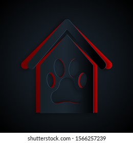 Paper cut Dog house and paw print pet icon isolated on black background. Dog kennel. Paper art style. Vector Illustration