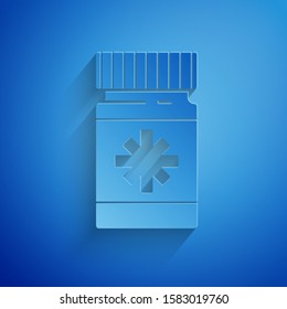 Paper cut Dog medicine bottle and pills icon isolated on blue background. Container with pills. Prescription medicine for animal. Paper art style. Vector Illustration