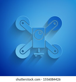 Paper cut Drone flying with action video camera icon isolated on blue background. Quadrocopter with video and photo camera symbol. Paper art style. Vector Illustration