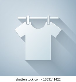 Corte de papel Icono de ropa de secado aislado en fondo gris. Camiseta limpia. Lávese la ropa en una cuerda con espinas de tela. Cuidado de la ropa y limpieza. Estilo de arte de papel. Vector
