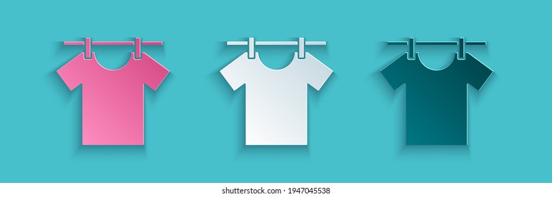Corte de papel Icono de ropa de secado aislado en fondo azul. Camiseta limpia. Lávese la ropa en una cuerda con espinas de tela. Cuidado de la ropa y limpieza. Estilo de arte de papel. Vector