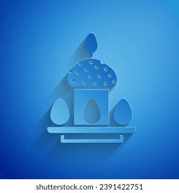 Paper cut Easter cake and eggs icon isolated on blue background. Happy Easter. Paper art style. Vector Illustration