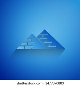 Paper cut Egypt pyramids icon isolated on blue background. Symbol of ancient Egypt. Paper art style. Vector Illustration