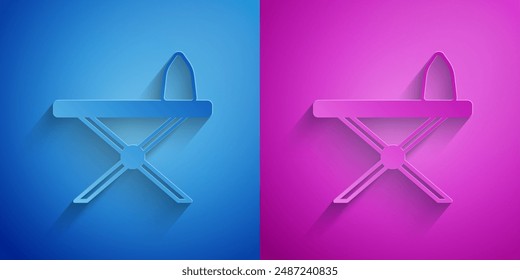 Paper cut Electric iron and ironing board icon isolated on blue and purple background. Steam iron. Paper art style. Vector