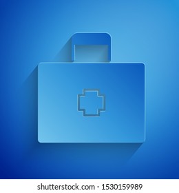 Paper cut First aid kit icon isolated on blue background. Medical box with cross. Medical equipment for emergency. Healthcare concept. Paper art style. Vector Illustration
