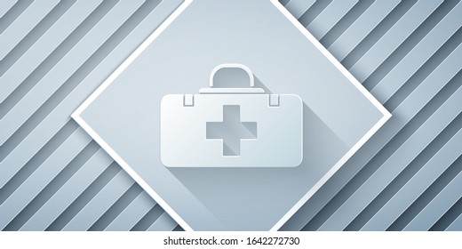 Paper cut First aid kit icon isolated on grey background. Medical box with cross. Medical equipment for emergency. Healthcare concept. Paper art style. Vector Illustration