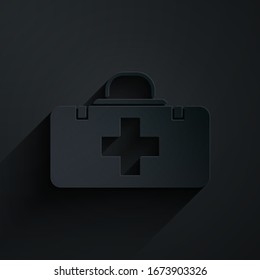 Icono del kit de primeros auxilios aislado en fondo negro. Caja médica con cruz. Equipo médico de emergencia. Concepto de salud. Estilo de arte de papel.  Ilustración vectorial