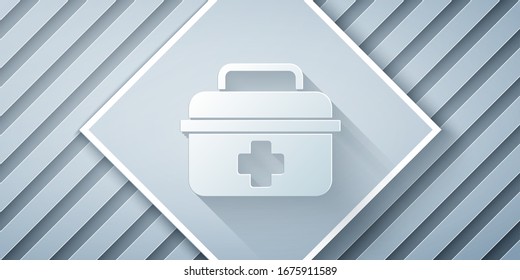Paper cut First aid kit icon isolated on grey background. Medical box with cross. Medical equipment for emergency. Healthcare concept. Paper art style. Vector Illustration