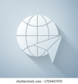 Paper cut Globe with flying plane icon isolated on grey background. Airplane fly around the planet earth. Aircraft world icon. Paper art style. Vector Illustration