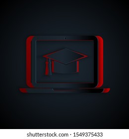 Paper cut Graduation cap on screen laptop icon isolated on black background. Online learning or e-learning concept. Paper art style. Vector Illustration