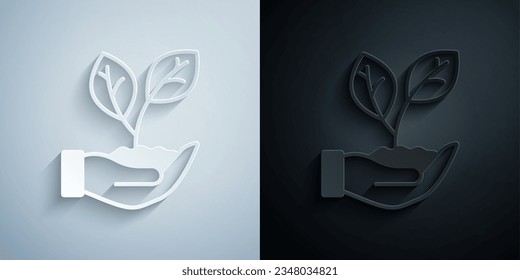 Cortar papel Mano sostiene una hoja del icono de la planta aislada en fondo gris y negro. Cuidado con la naturaleza. Brotes de hojas con protección ambiental. Estilo de arte de papel. Vector