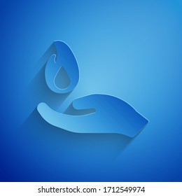 Paper cut Hand holding a fire icon isolated on blue background. Paper art style. Vector Illustration