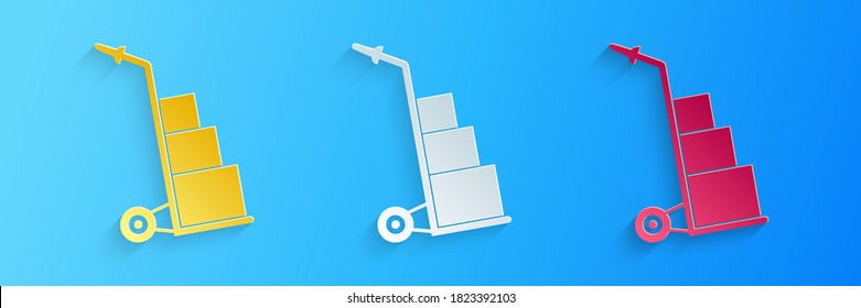 Paper cut Hand truck and boxes icon isolated on blue background. Dolly symbol. Paper art style. Vector.