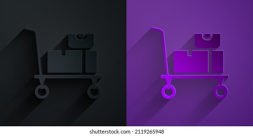 Paper cut Hand truck and boxes icon isolated on black on purple background. Dolly symbol. Paper art style. Vector