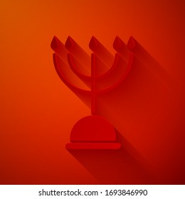 Paper cut Hanukkah menorah icon isolated on red background. Hanukkah traditional symbol. Holiday religion, jewish festival of Lights. Paper art style. Vector Illustration