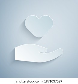 Paper cut Heart in hand icon isolated on grey background. Hand giving love symbol. Valentines day symbol. Paper art style. Vector