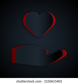 Paper cut Heart in hand icon isolated on black background. Hand giving love symbol. Valentines day symbol. Paper art style. Vector